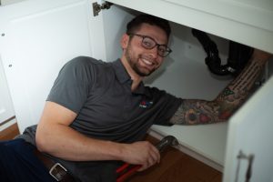 Friendly Plumber Fixing Sink