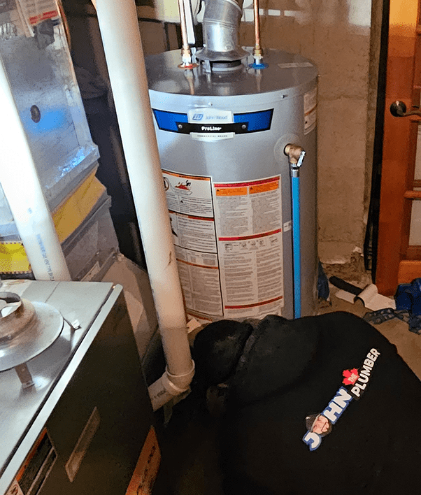 Plumber working on a gas water heater in Nepean