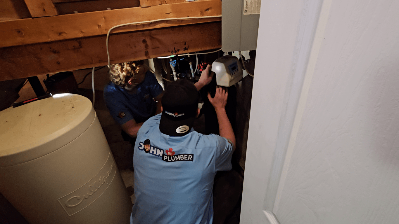 Ottawa plumbers examining plumbing equipment and connections during a residential plumbing inspection