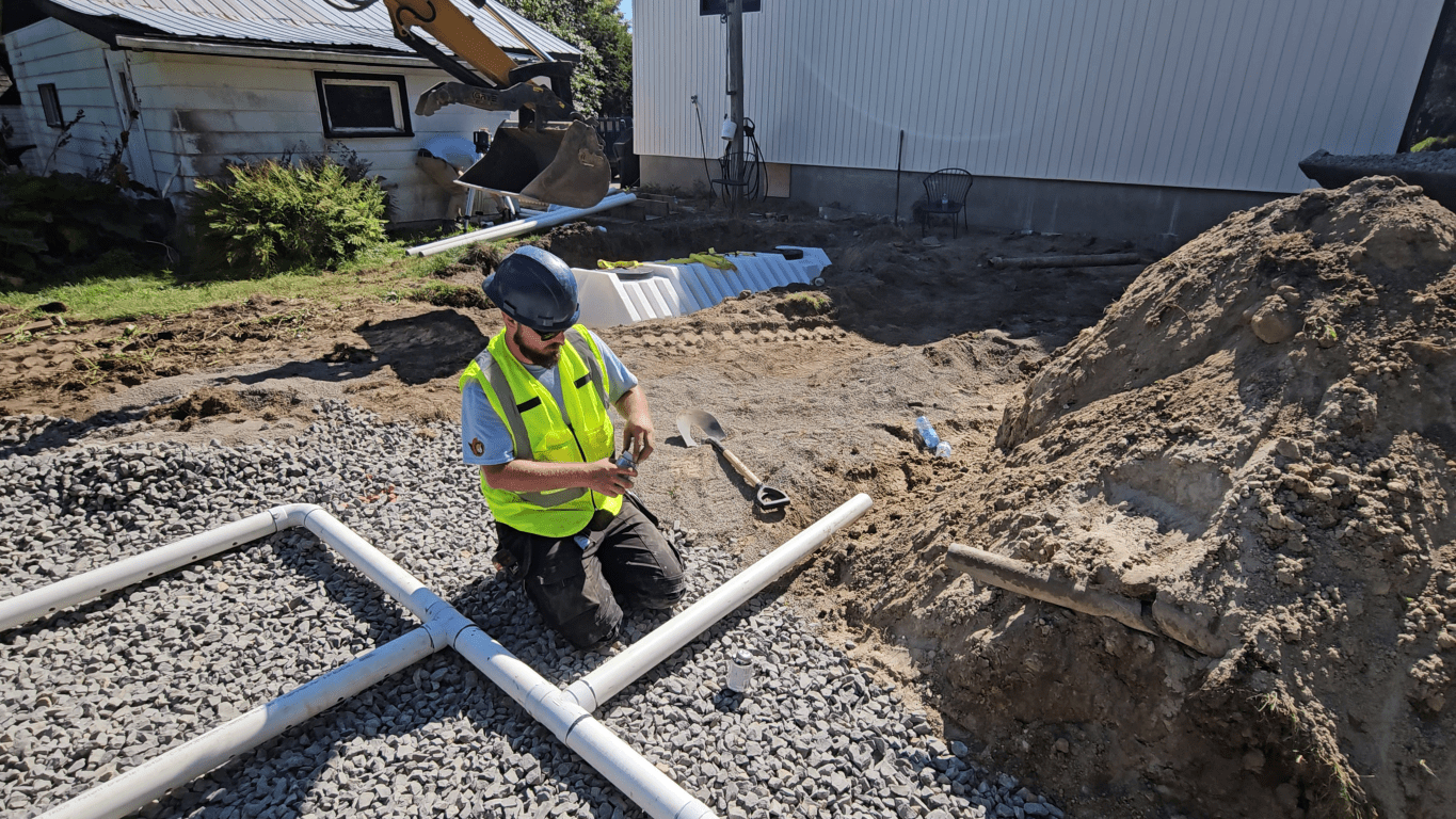 Plumber repairing septic field piping in Ottawa
