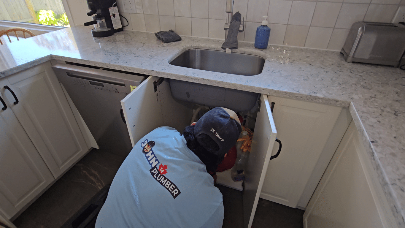 Plumber mechanically snaking a clogged kitchen drain in Ancaster